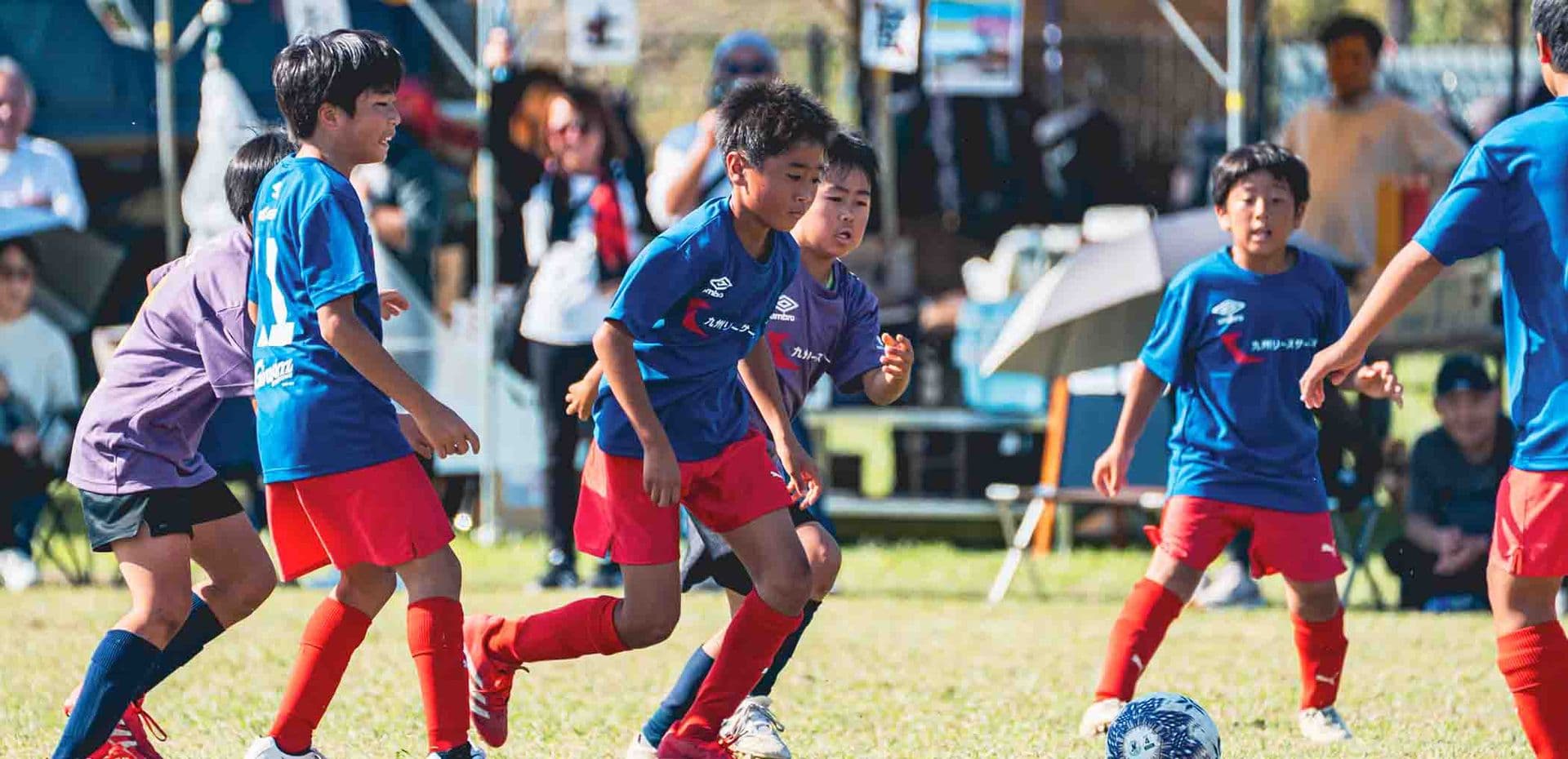 試合でボールを追うジュニア選手たち